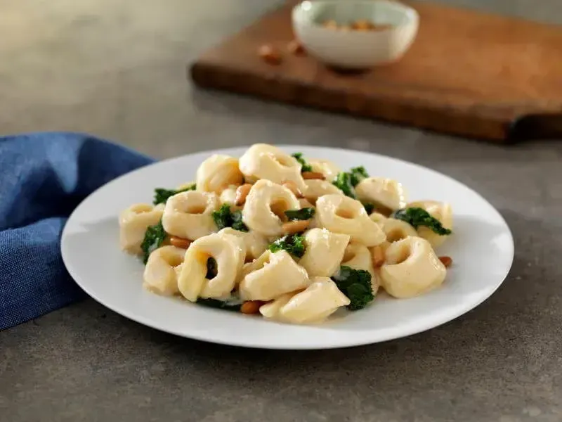 Barilla® Three Cheese Tortellini with Creamy Parmigiano Sauce, Kale and Pine Nuts Recipe | US_PROD-b8793f63-dca4-4634-b3d8-ec4bf7033b9d